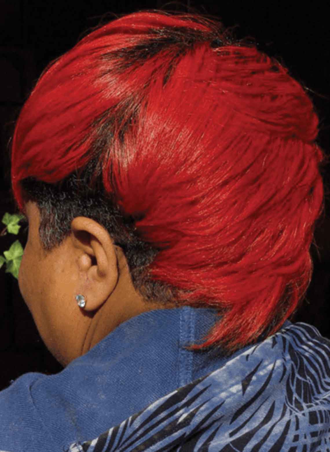 back view of person with red hair and layered mohawk, person has ear piercing in one ear