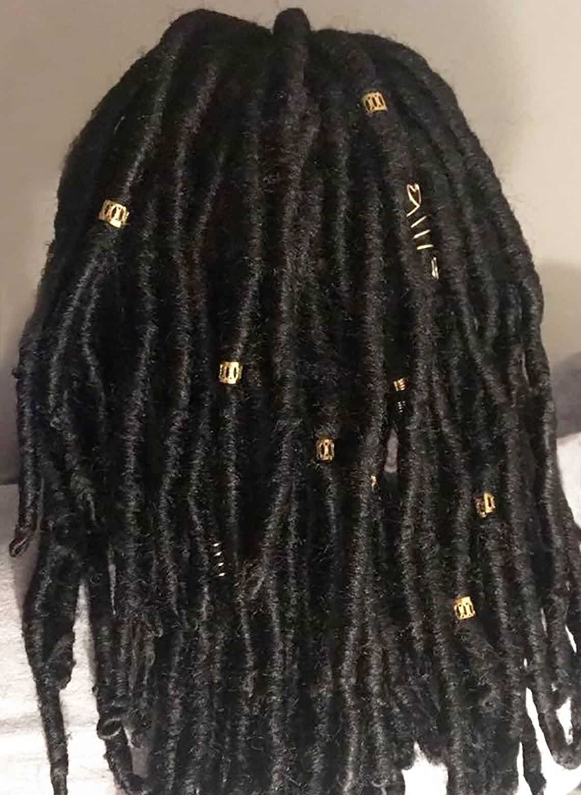 person with dreads and metal cuffs
