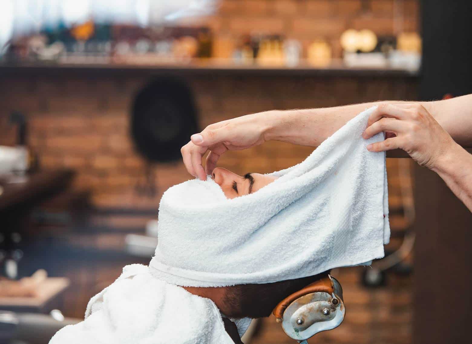 person getting hot towel in the barber shave