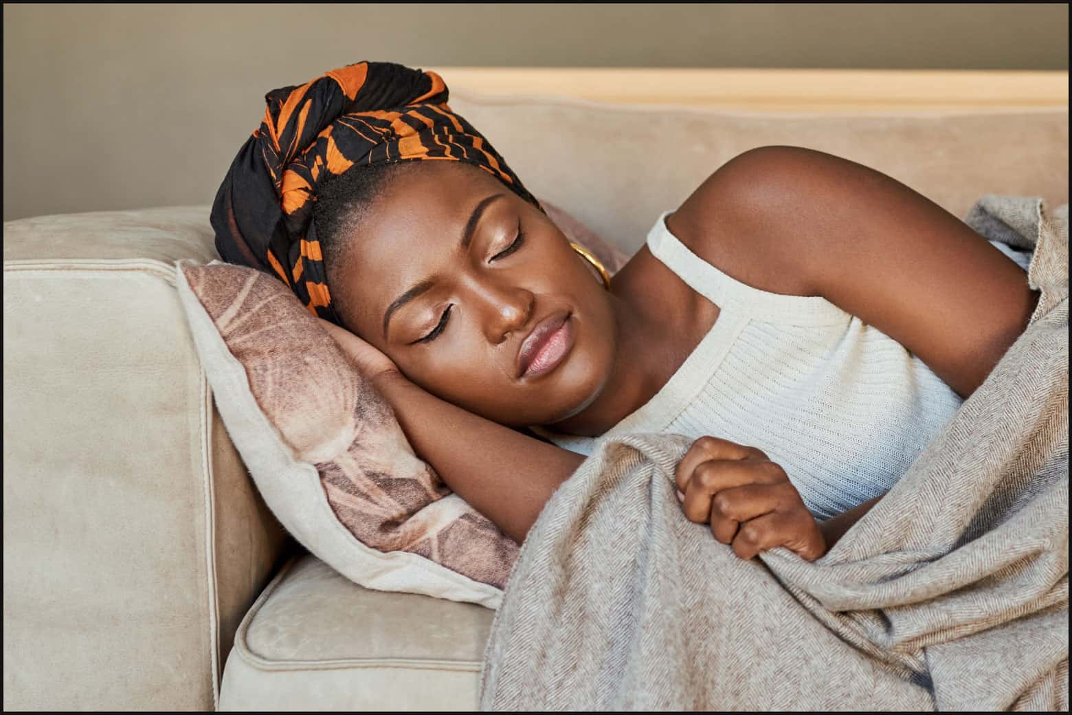woman with wrapped hair sleeping on the couch