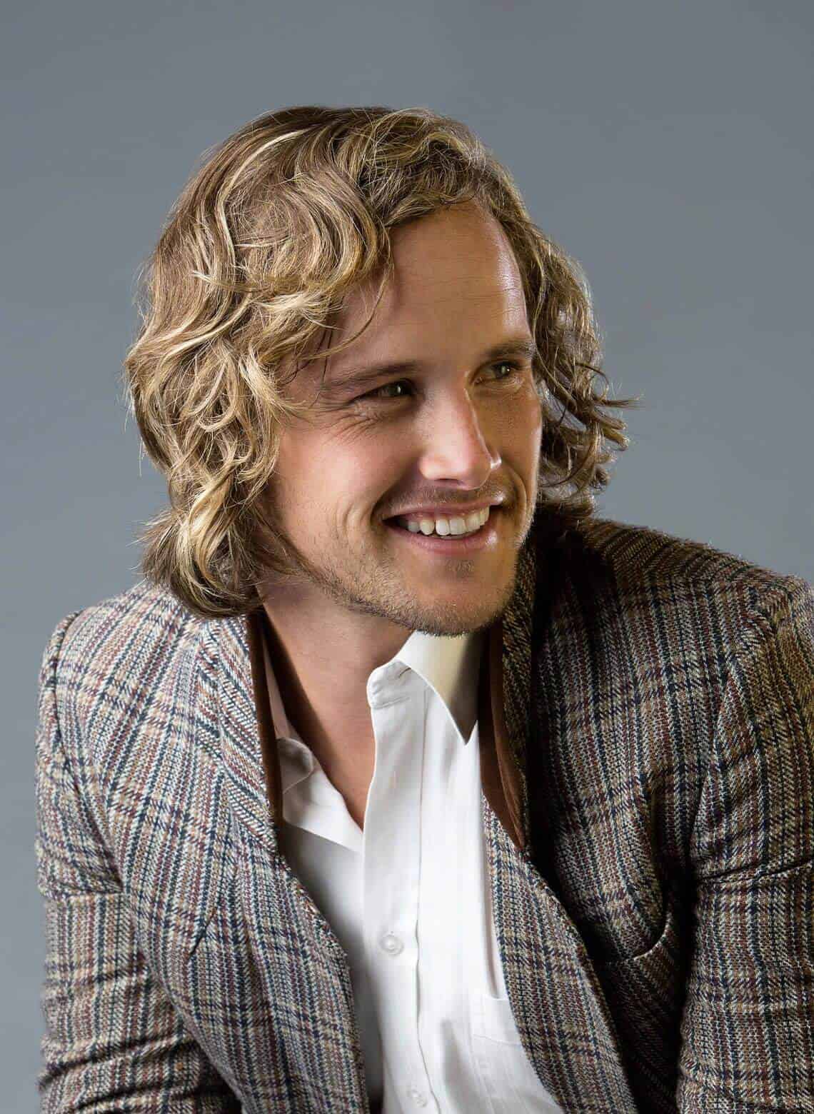 man with side swept curls