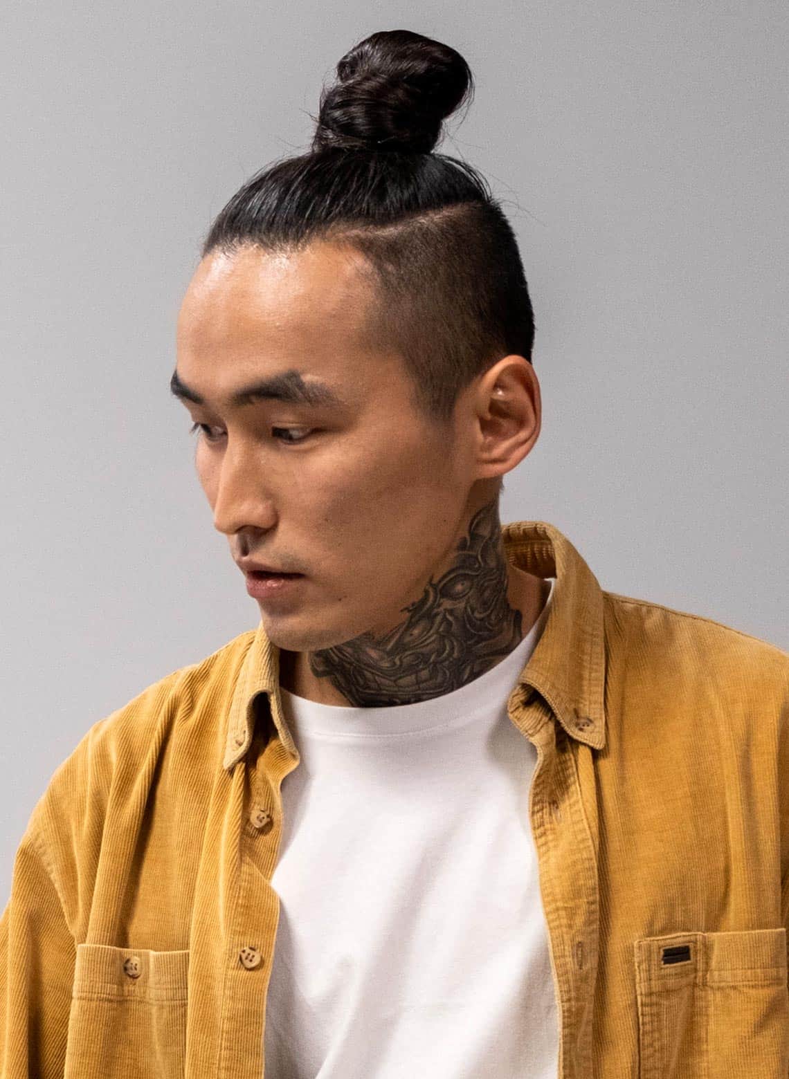 man with medium top knot hairstyle