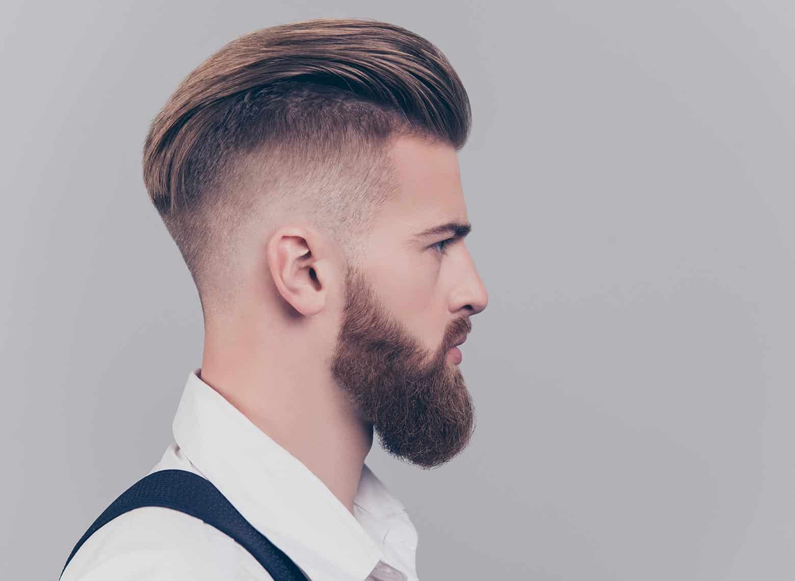 man with brushed back hair and mid fade