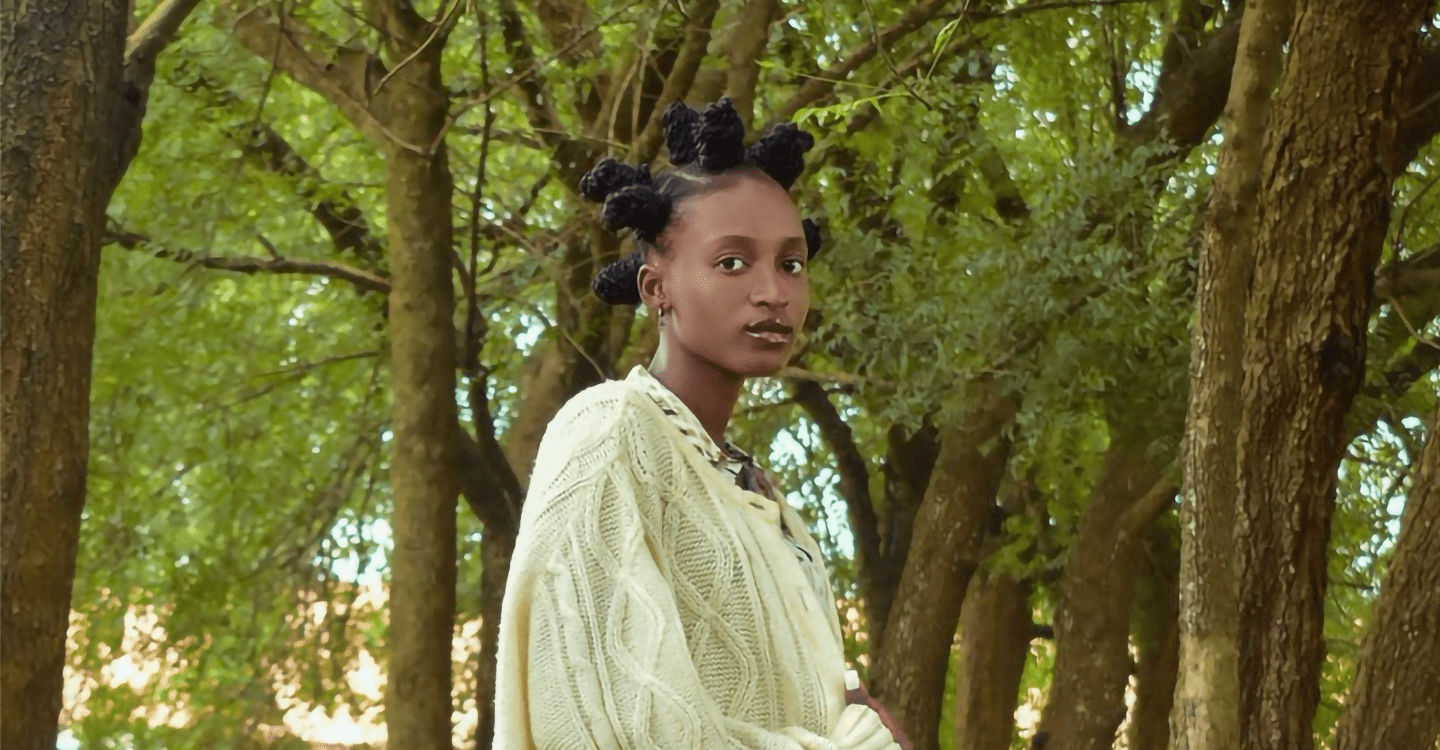 woman in bantu knots in front of trees