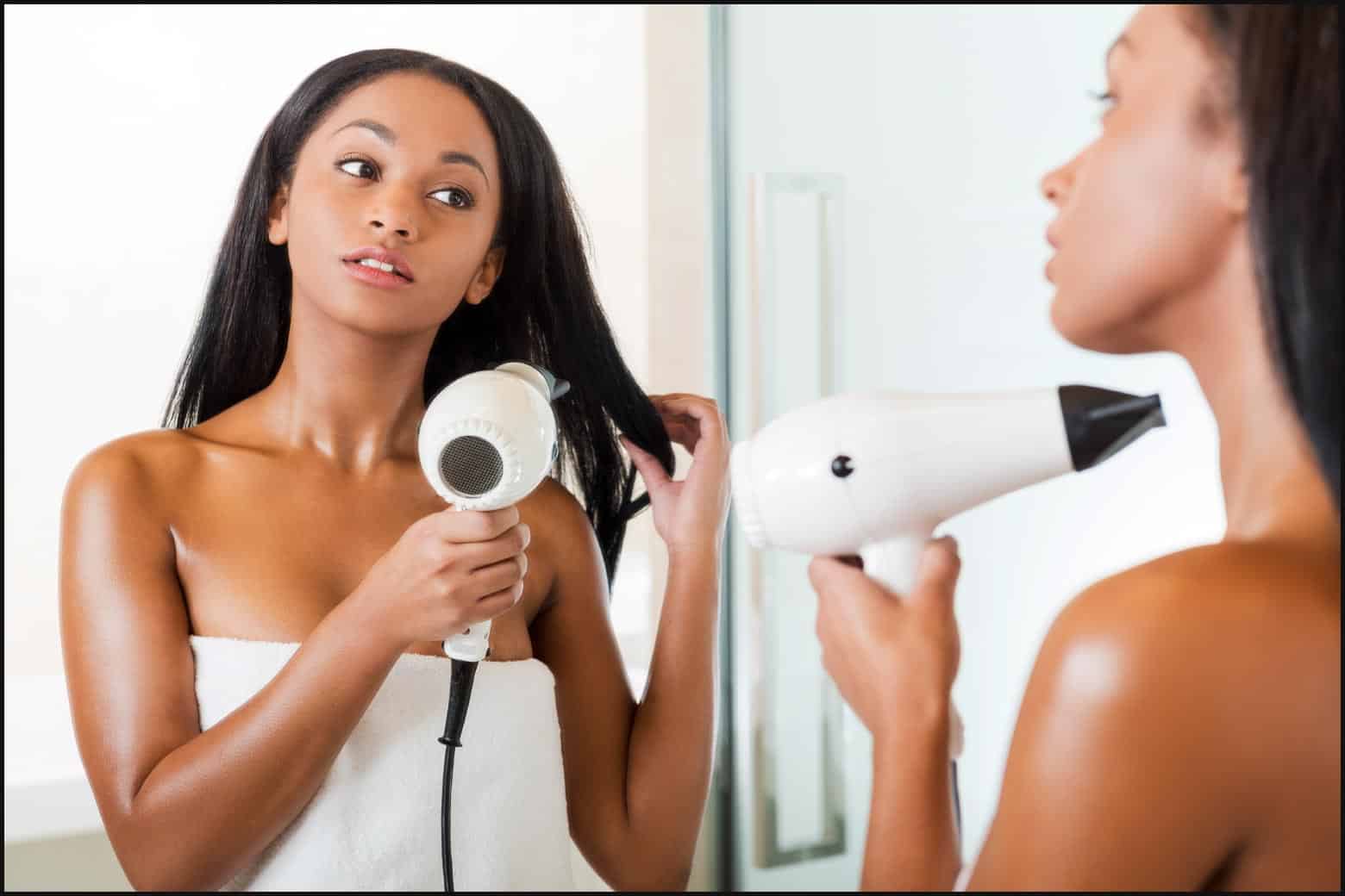 woman blow drying hair in the bathroom