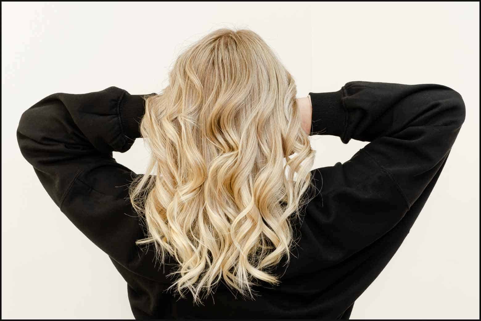 person from the back with wavy blonde hair and wearing a black sweater