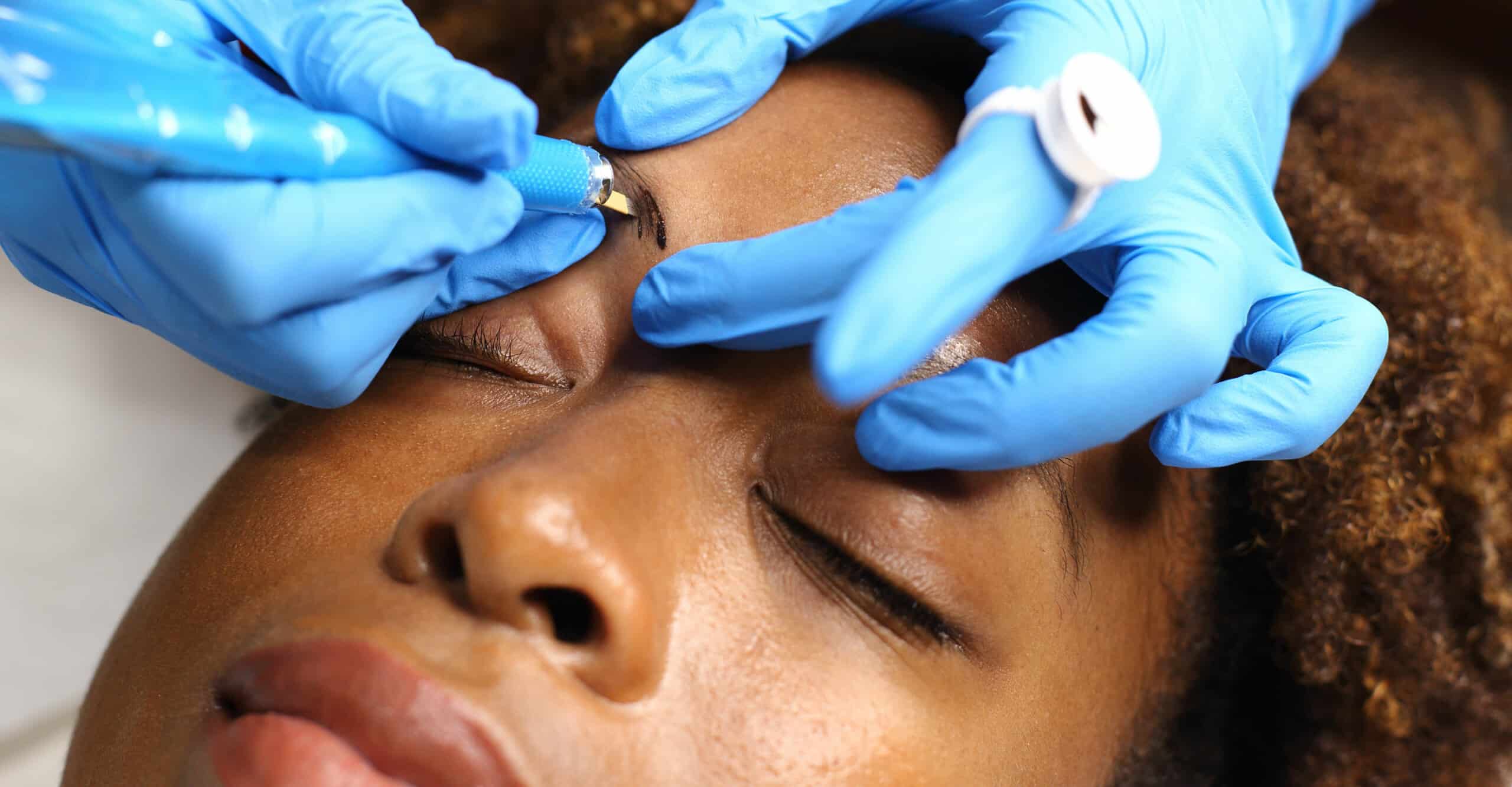 Woman is relaxed while laying down and getting her eyebrows microbladed.