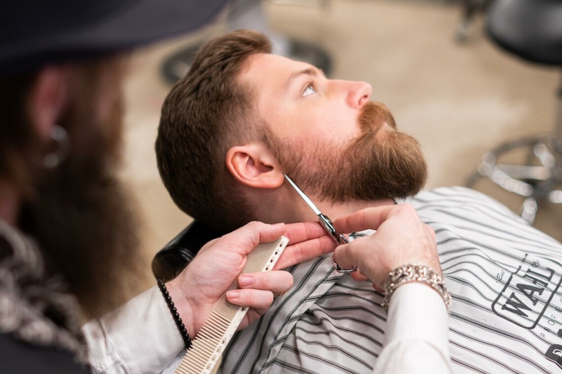 man getting beard trimmed in barber shop