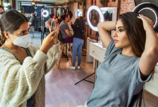 Stylist takes a photo of client to use for salon marketing.