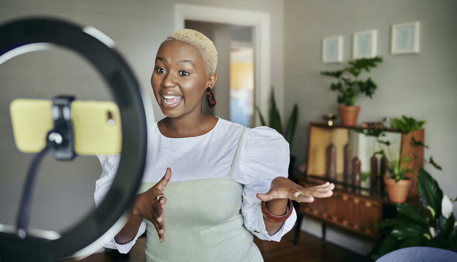 Black female influencer recording a video on a ring light