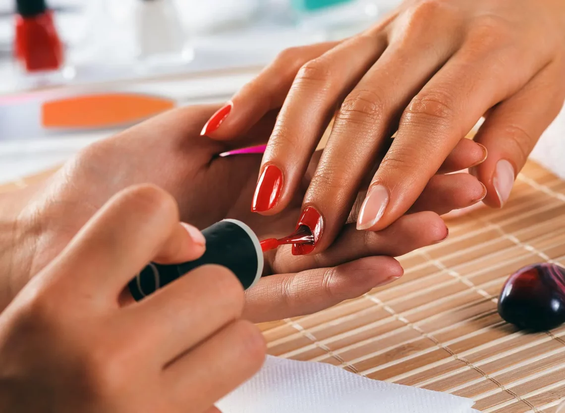 nail technician painting nails with vinylux polish