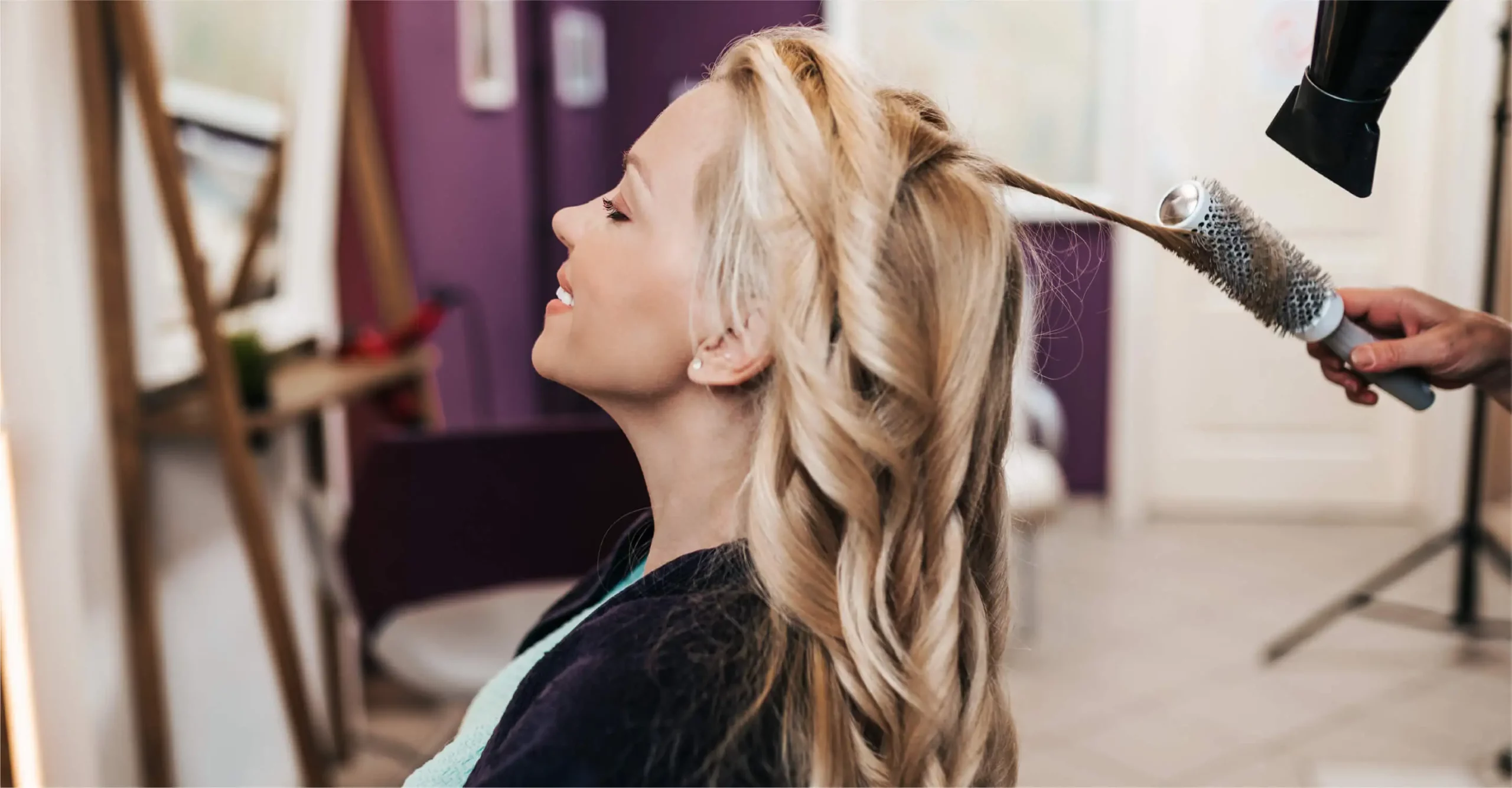 woman dyeing her hair blonde at a salon
