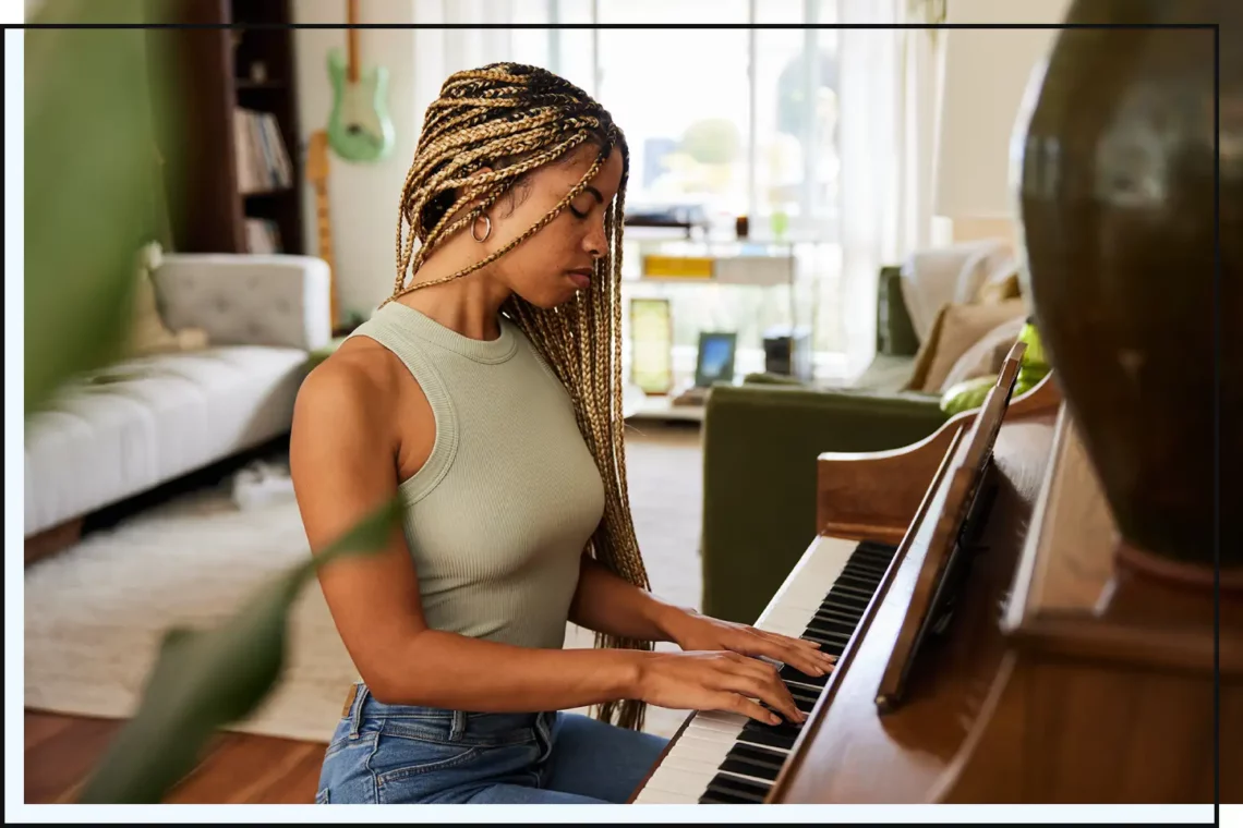 woman with blonde goddess braids playing the piano