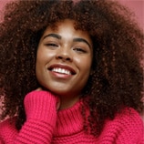 person with curly hair and sweater