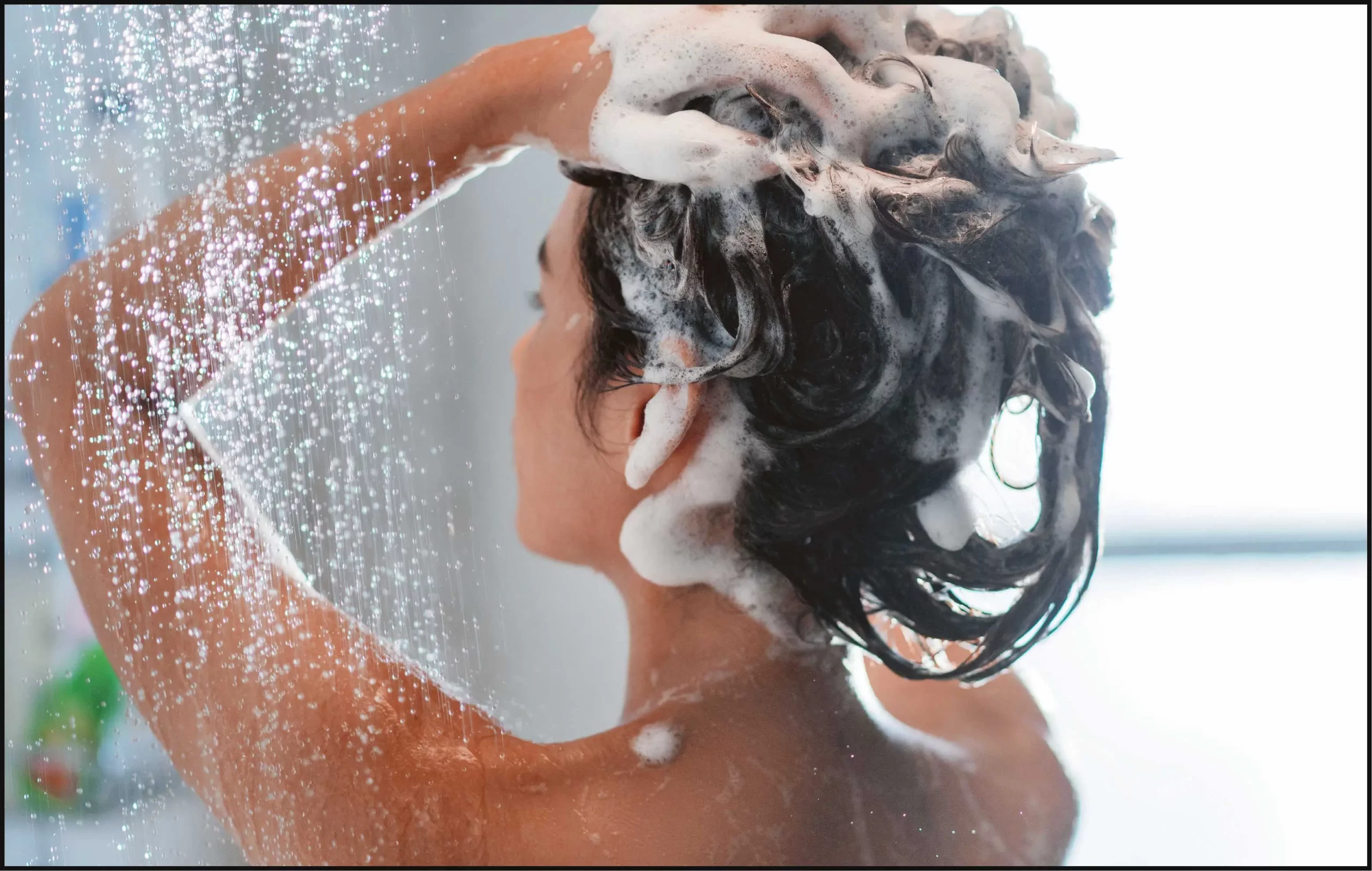Woman using hydrating shampoo to wash hair.