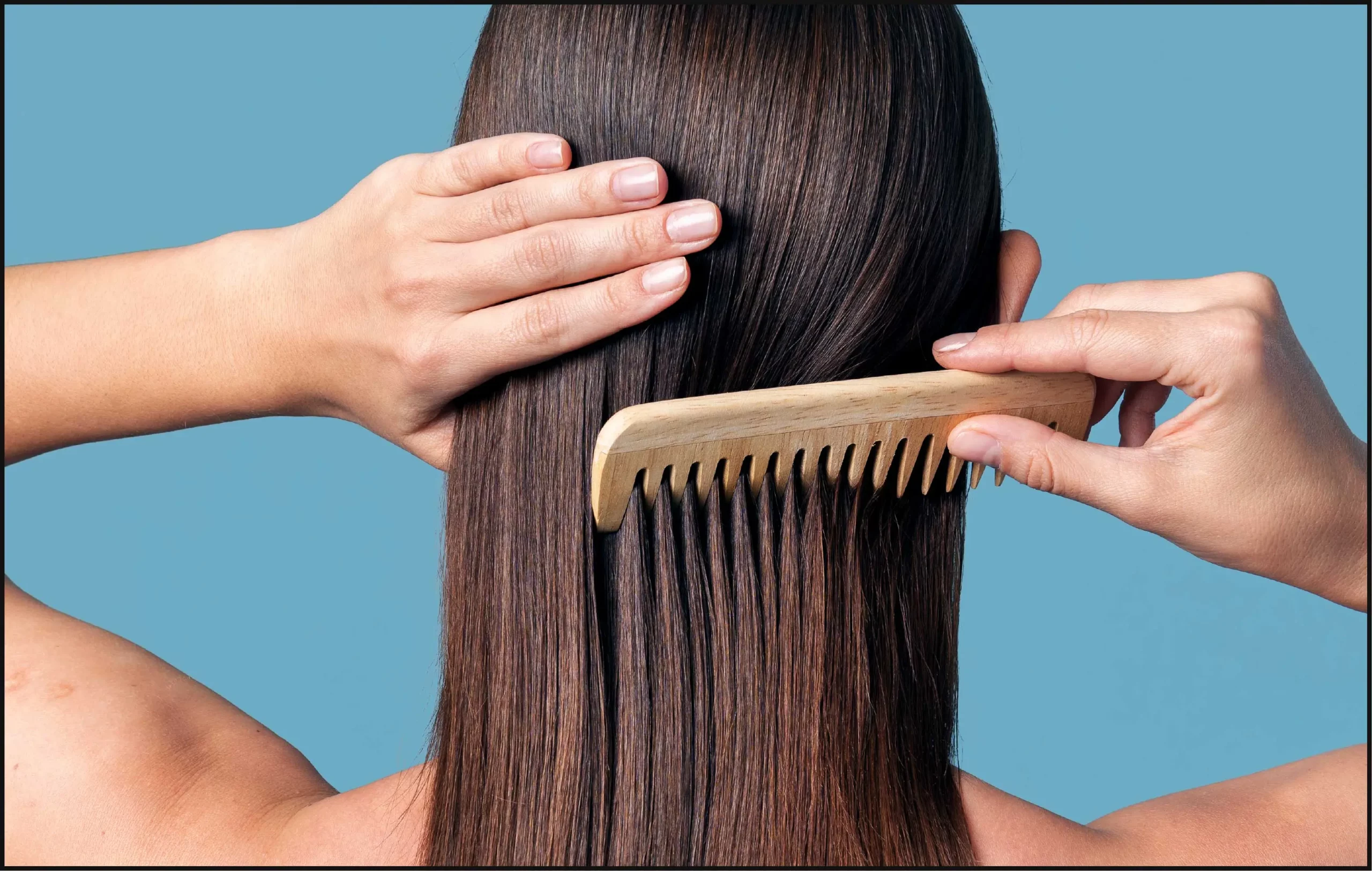 Woman gently combing hair with a wide tooth comb.