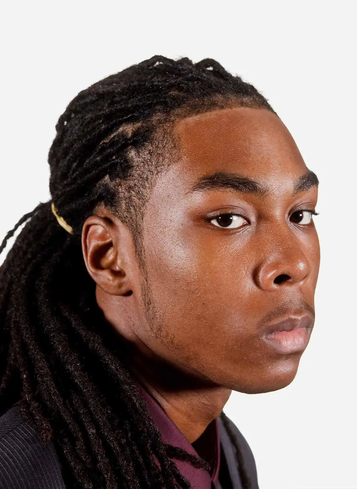 Image of man with locs in a low ponytail. 