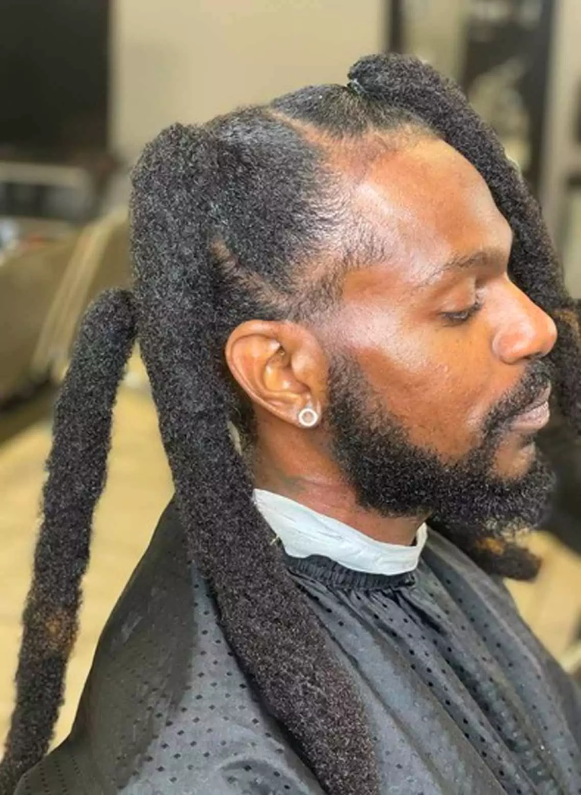 Image of man with pigtail locs. 