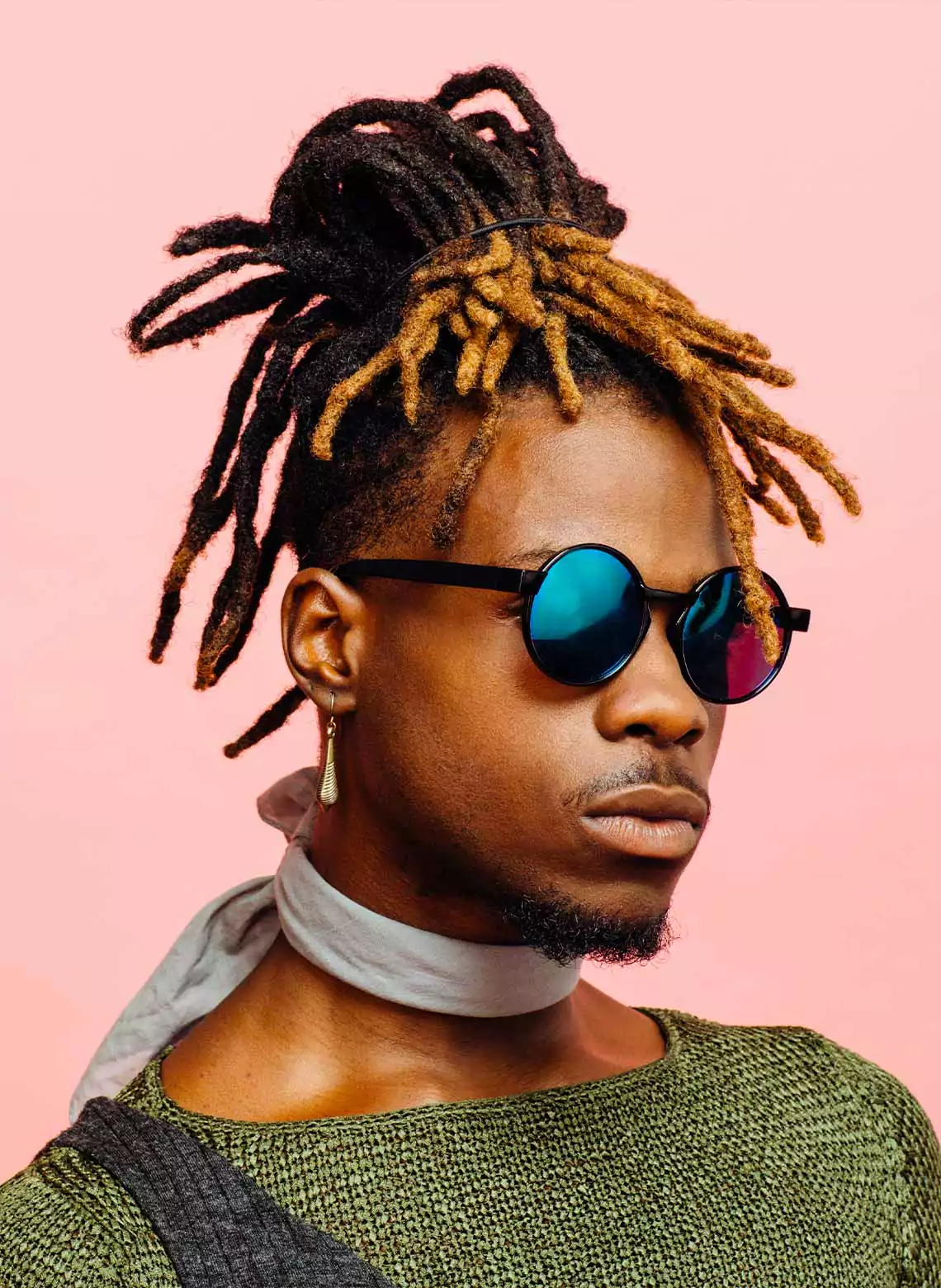 Image of man with locs in a top knot. 