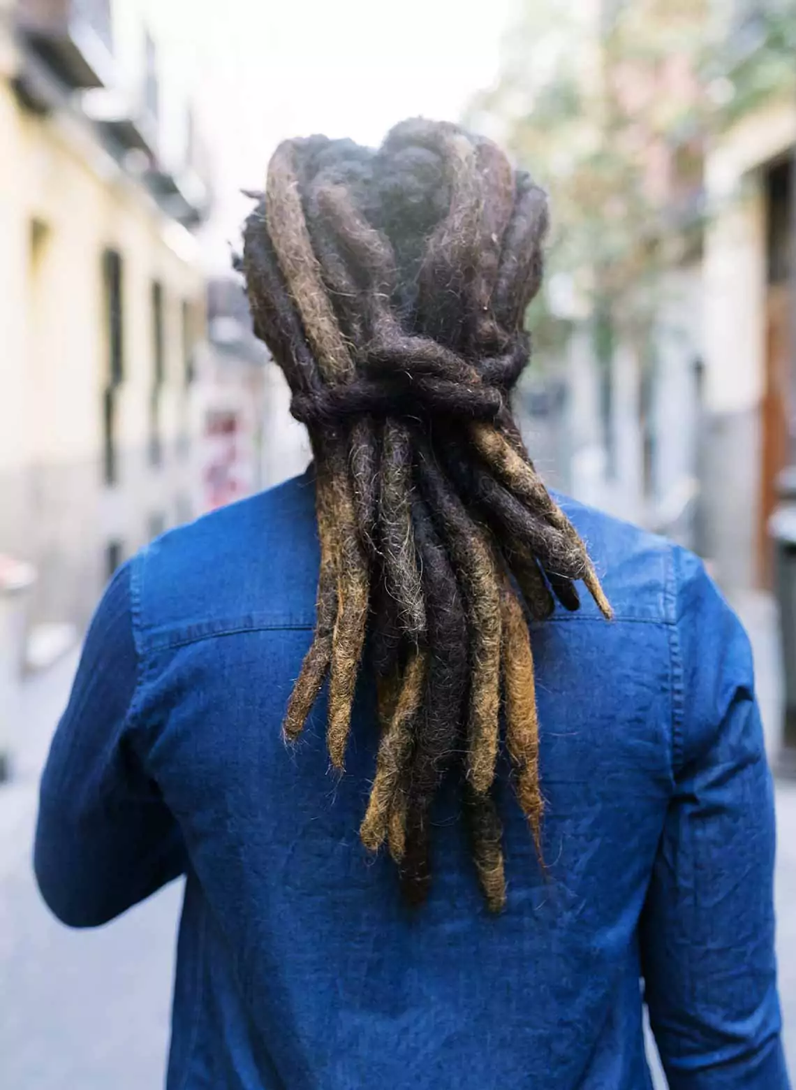 Image of man with dreadlocks tied in a knot. 
