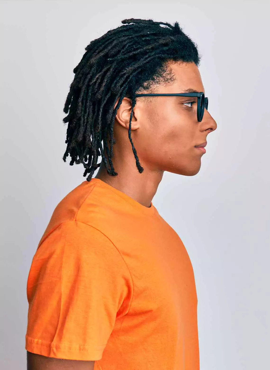 Image of man with combed back locs. 