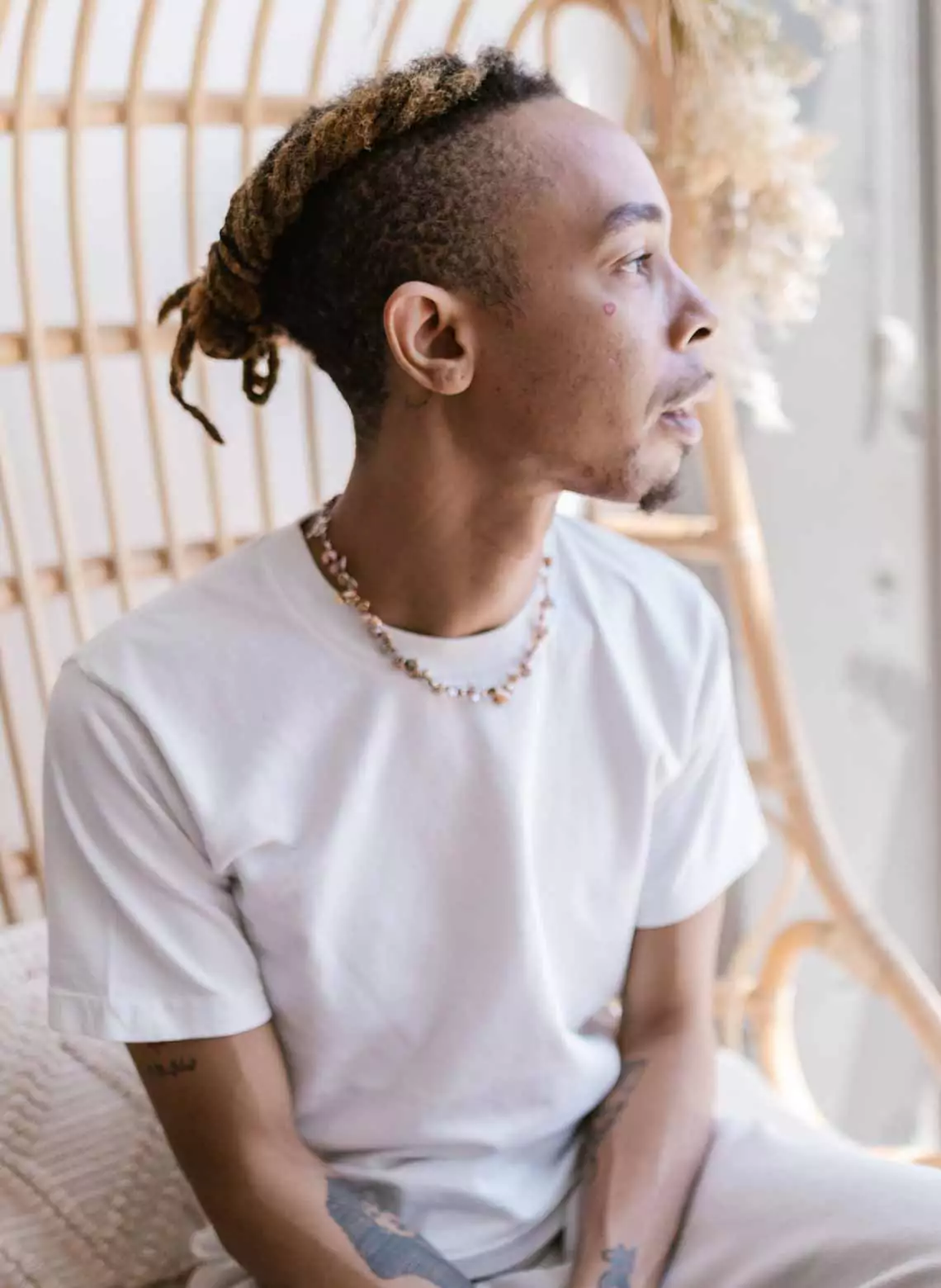 Image of man with braided faux hawk locs. 