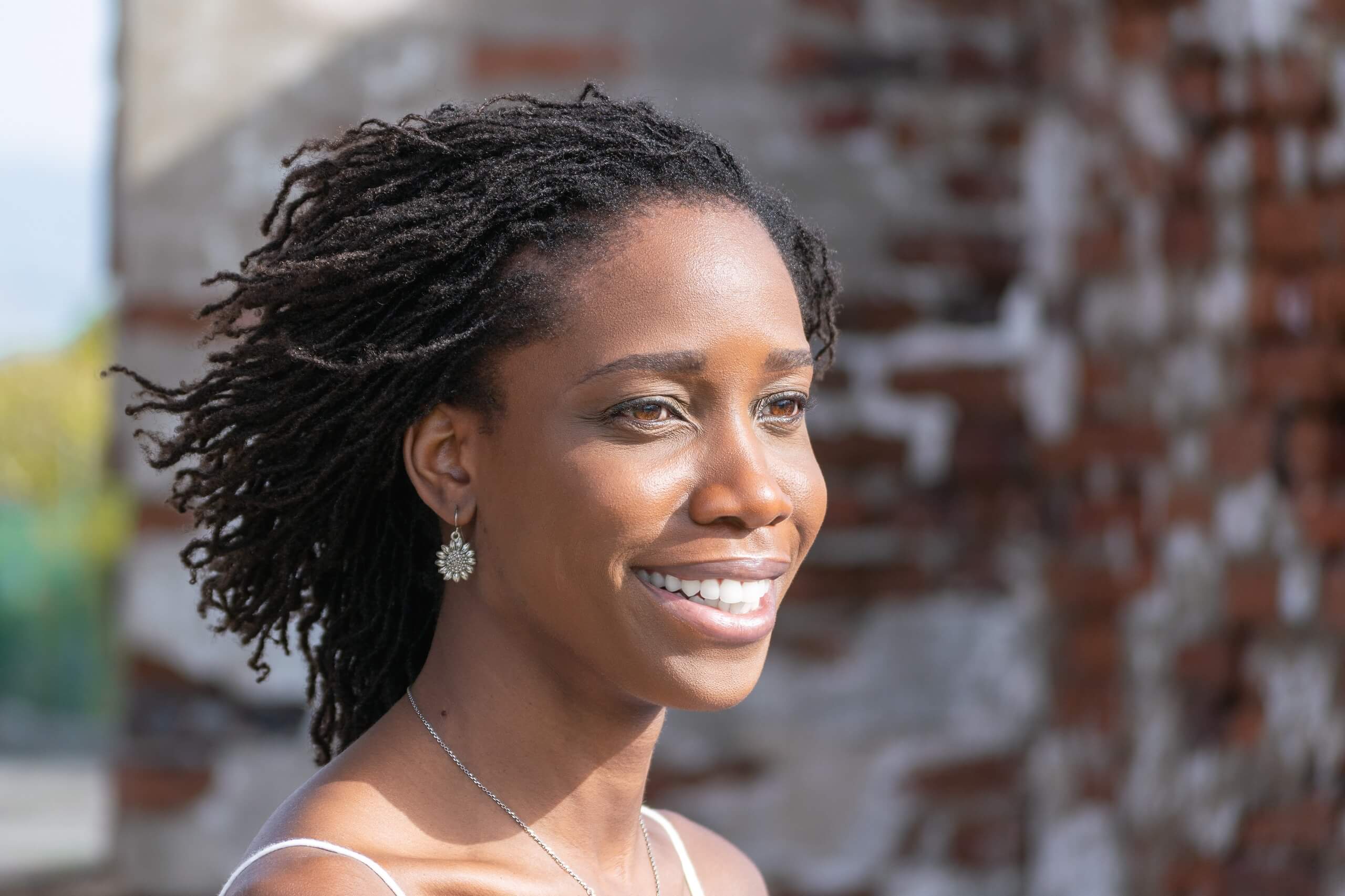 woman with microlocs hairstyle smiling