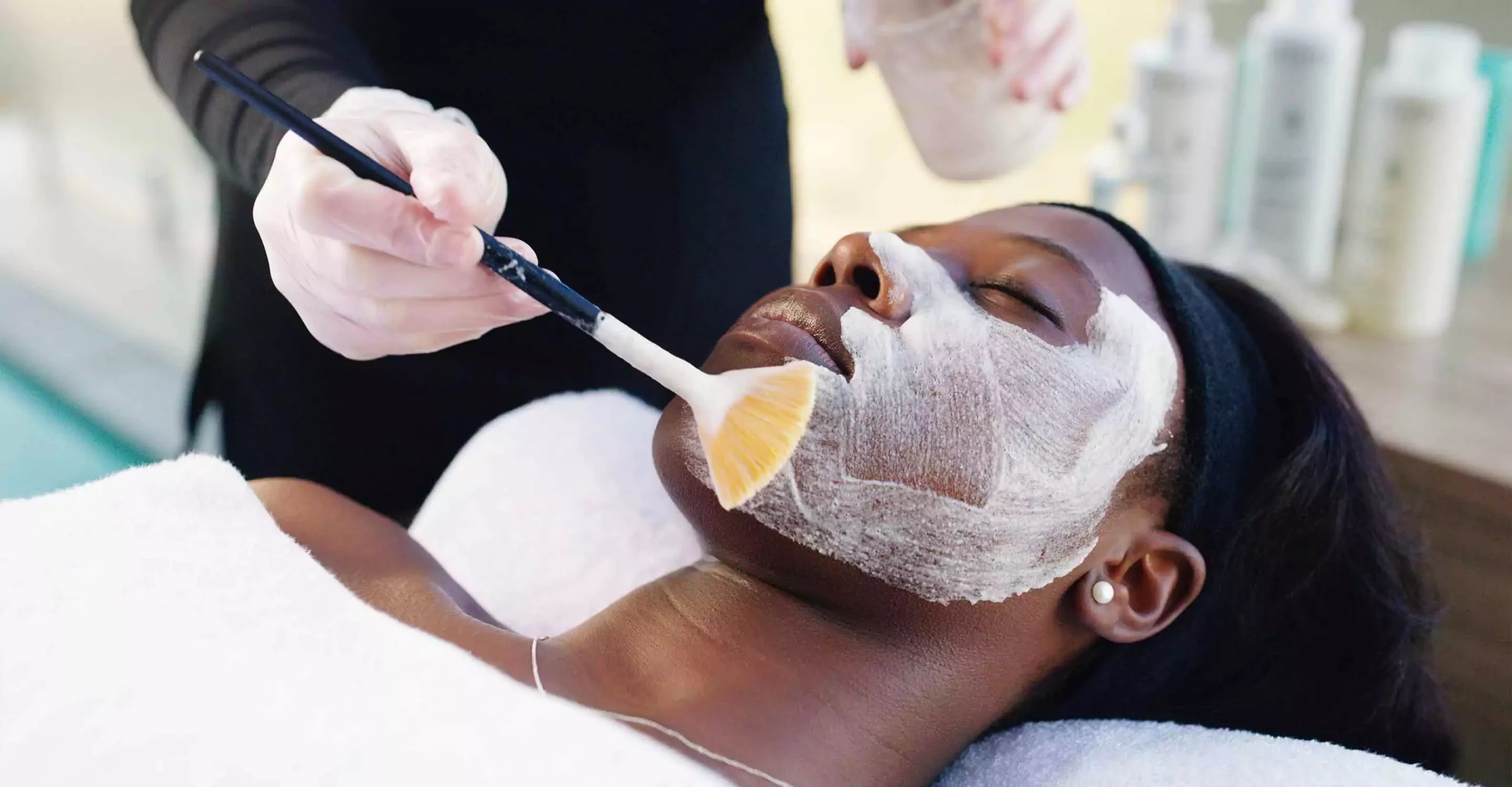 Woman receiving a chemical peel treatment from her esthetician.