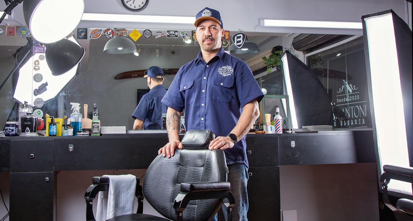 a barber posing behind a barber chair